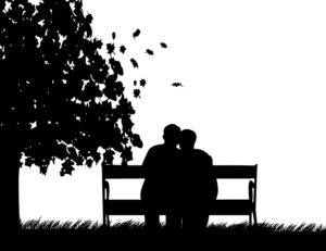 Silhouette of couple sitting on bench