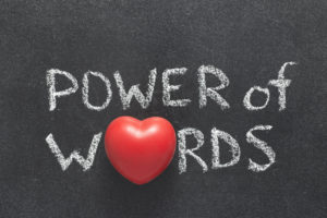 power of words phrase handwritten on blackboard with heart symbol instead of O