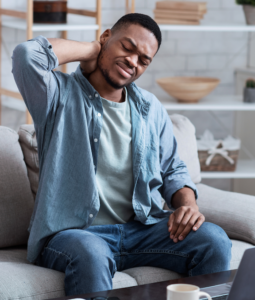 man with stiff neck sitting on couch 