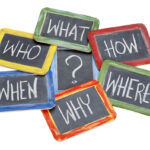 What, when, where, why, how, who questions - white chalk handwriting on vintage slate blackboards in colorful wood frames