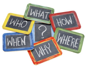 What, when, where, why, how, who questions - white chalk handwriting on vintage slate blackboards in colorful wood frames